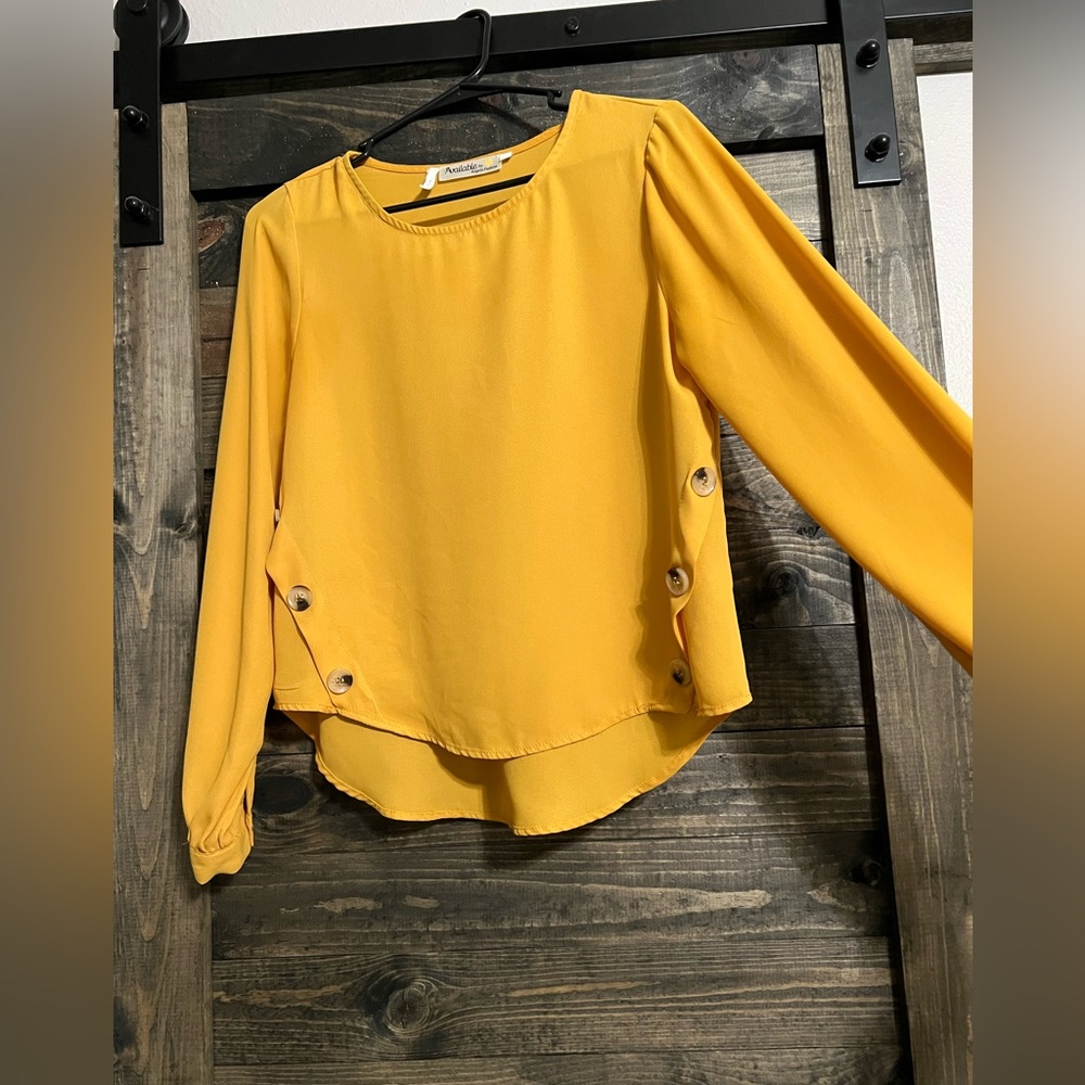 Mustard top with 3 button detail down sides. Looks great w/ high waist slacks!